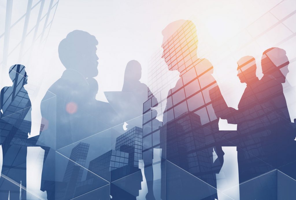 Silhouettes of business people working and communicating over skyscraper background. Concept of teamwork. Toned image double exposure